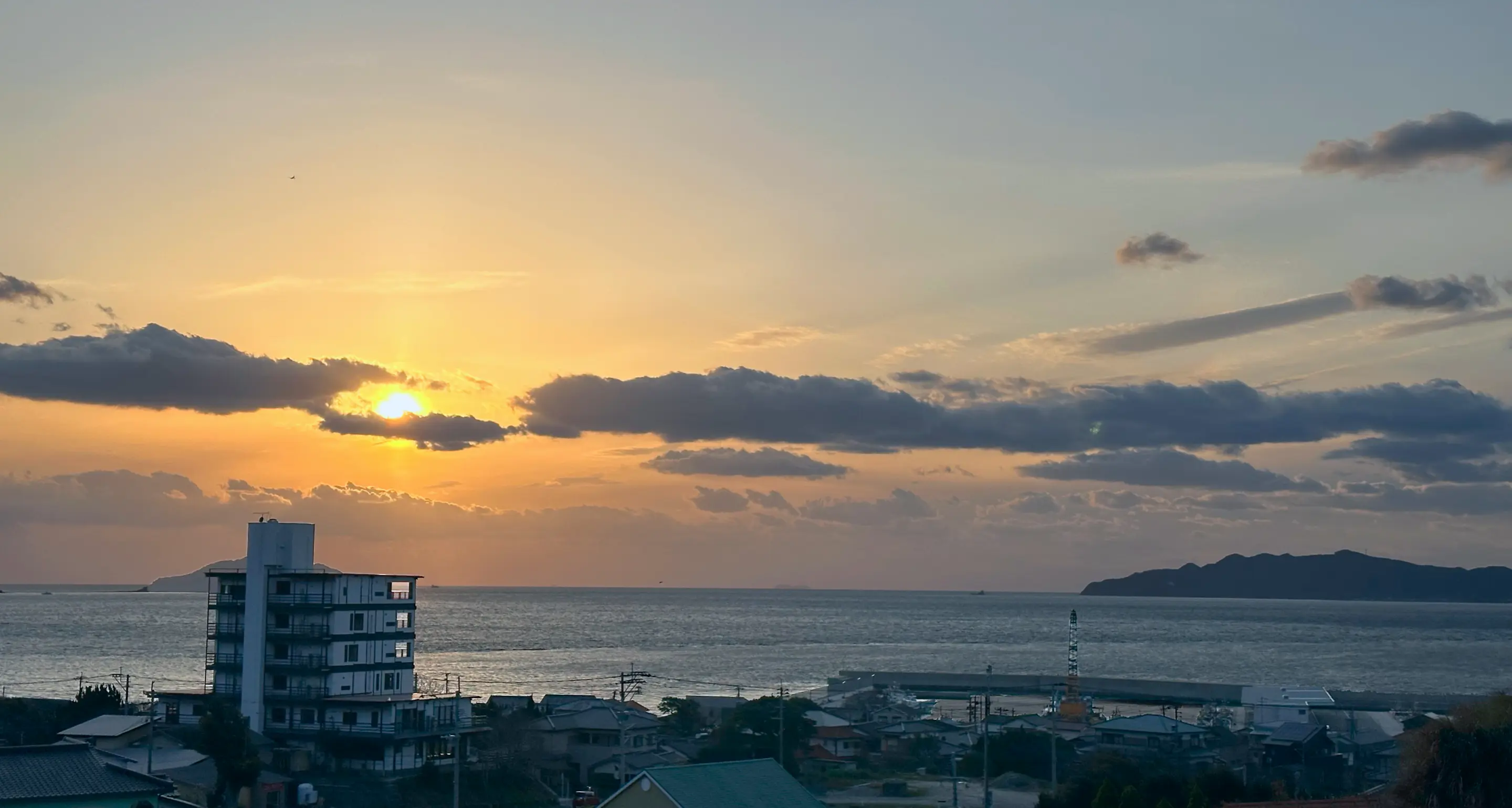 民宿しらいしと夕日がうつる